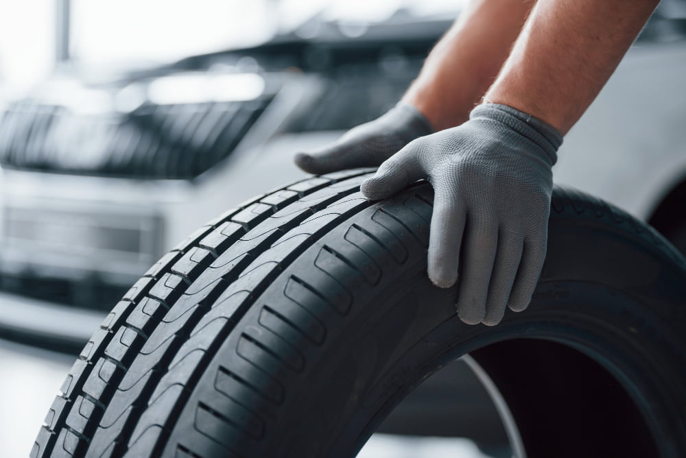 Melhores marcas de pneu nacionais? 2 hands only mechanic holding tire repair garage replacement winter summer tires 3