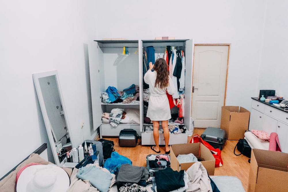 Como se livrar do acúmulo de coisas no armário de forma eficiente? 1 senhora de aparencia agradavel dentro do apartamento moderno prepare se para viajar