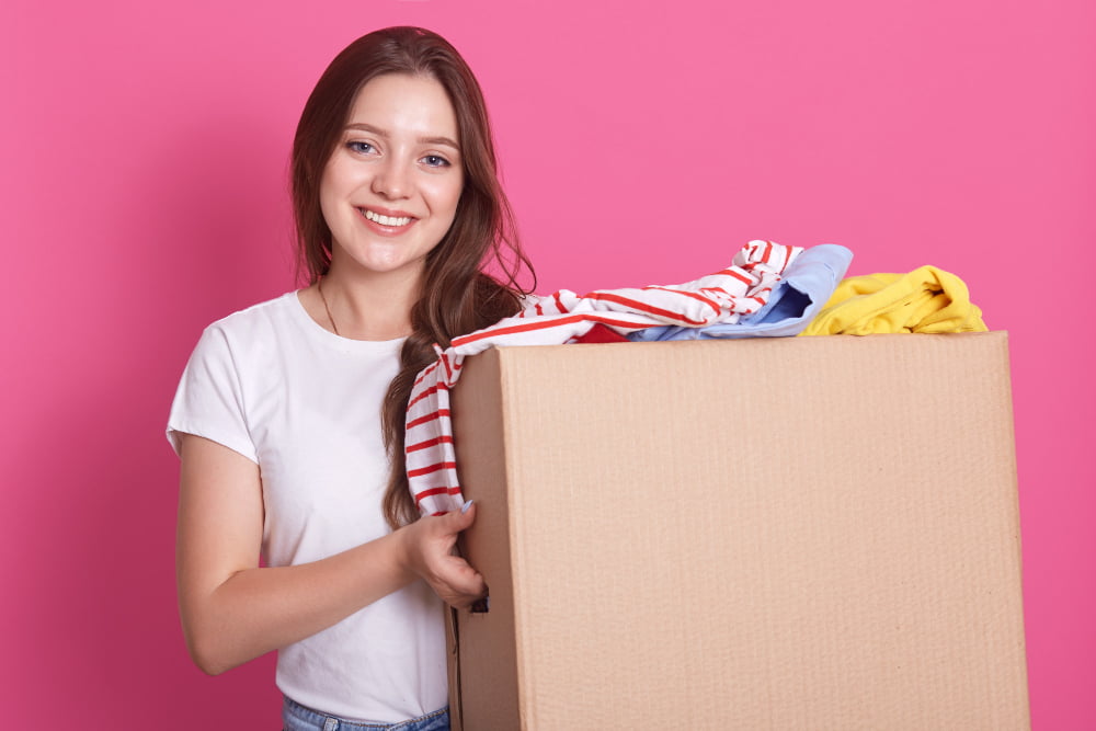 Como se livrar do acúmulo de coisas no armário de forma eficiente? 2 tiro horizontal de carrinhos femininos sorrindo perto de ambos com roupas reutilizaveis para pessoas pobres